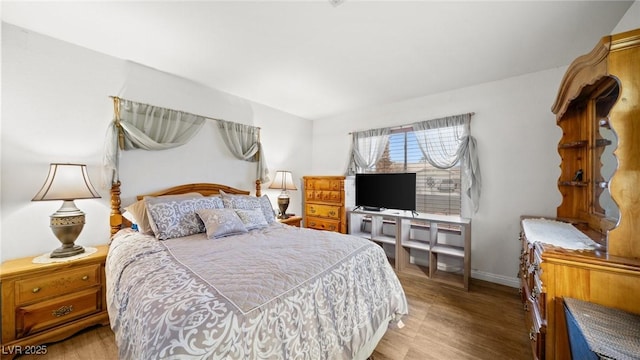 bedroom featuring wood finished floors and baseboards