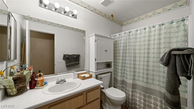 bathroom with vanity, curtained shower, and toilet