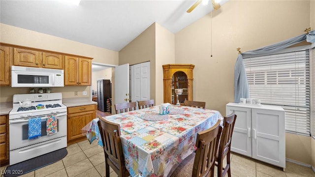 kitchen with lofted ceiling, light tile patterned flooring, white appliances, a ceiling fan, and light countertops