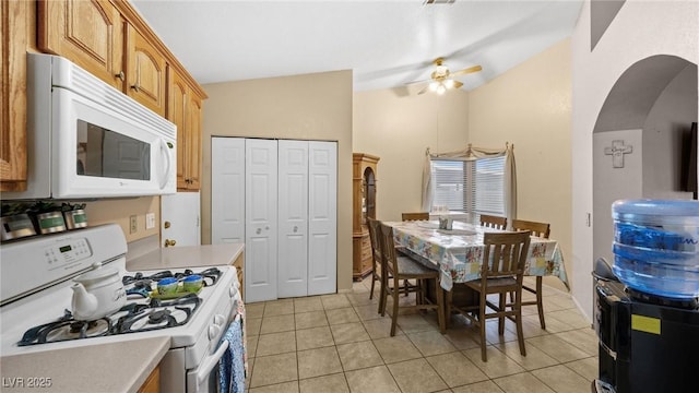 kitchen with white appliances, arched walkways, brown cabinetry, lofted ceiling, and light countertops