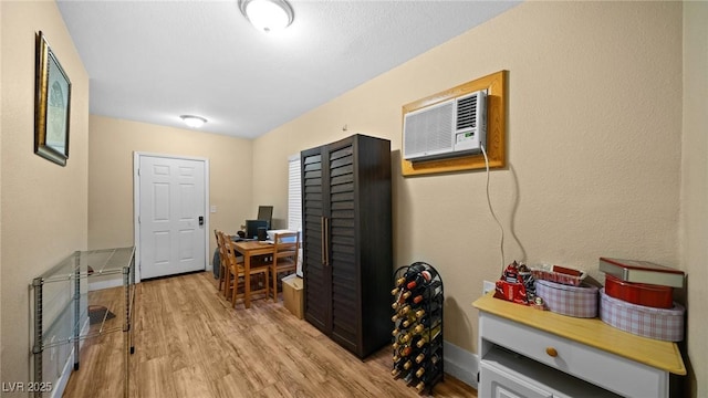 office space featuring an AC wall unit and light hardwood / wood-style flooring