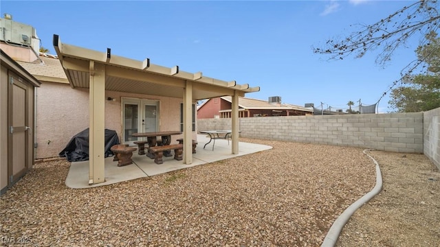 view of yard featuring french doors, a patio area, and a fenced backyard