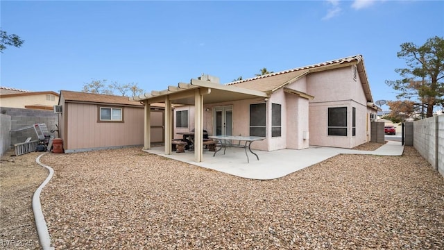 rear view of house featuring a patio area, a fenced backyard, stucco siding, and french doors