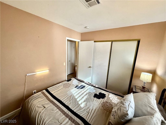 bedroom with a closet, visible vents, and baseboards