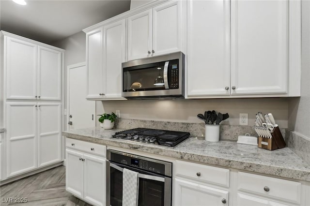 kitchen featuring light stone counters, white cabinets, and appliances with stainless steel finishes