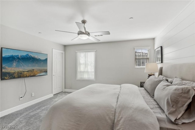 bedroom with visible vents, baseboards, light colored carpet, and ceiling fan