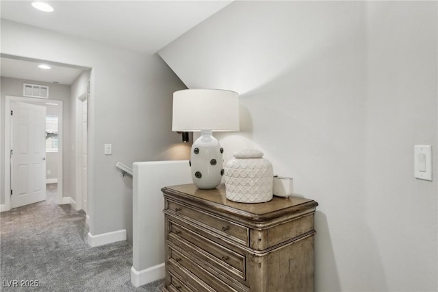 hall featuring carpet, visible vents, baseboards, recessed lighting, and vaulted ceiling