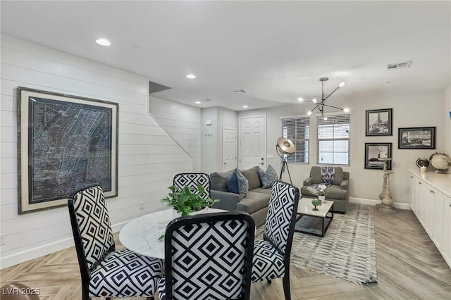 dining area featuring visible vents, baseboards, wood walls, recessed lighting, and an inviting chandelier