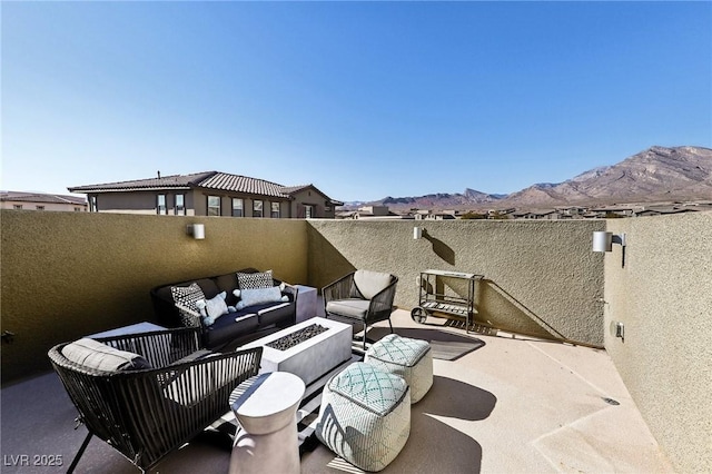 view of patio / terrace with a mountain view and an outdoor living space with a fire pit