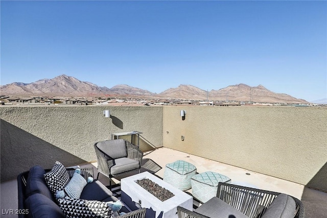 view of patio / terrace with a mountain view and a fire pit