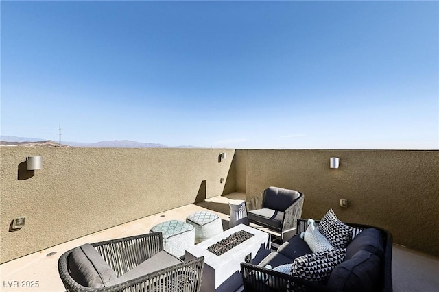 view of patio featuring a mountain view and an outdoor living space with a fire pit