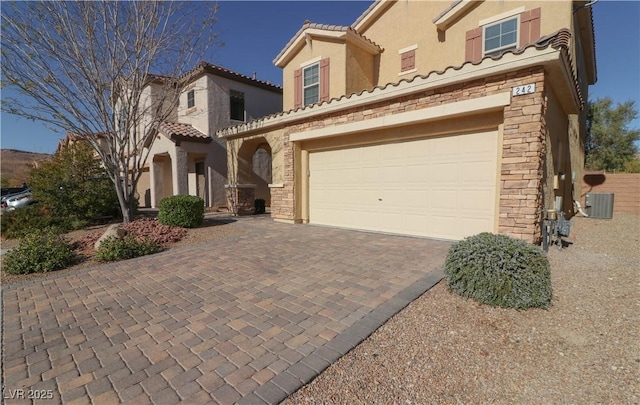 view of front of home with a garage and central AC