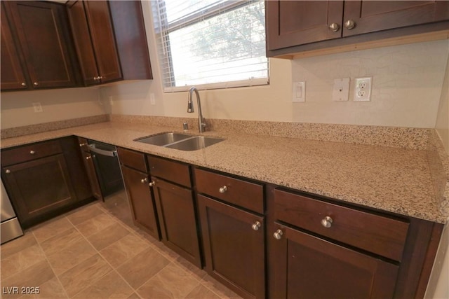 kitchen with light stone countertops, sink, and dark brown cabinets