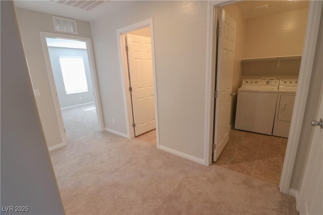 corridor featuring washing machine and dryer and light colored carpet