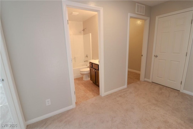 unfurnished bedroom with ensuite bathroom and light carpet