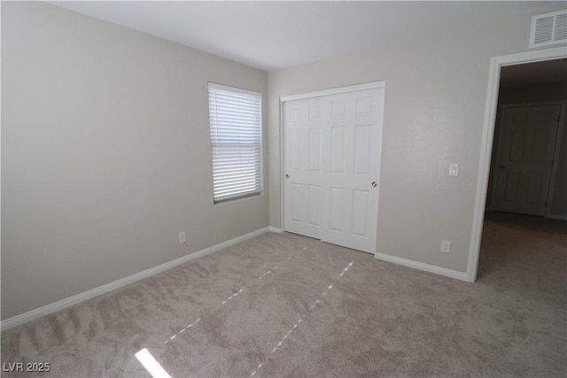 unfurnished bedroom with a closet and light carpet