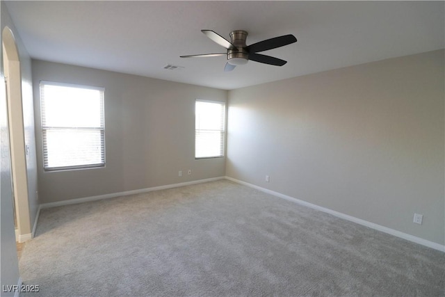 unfurnished room with light colored carpet and ceiling fan