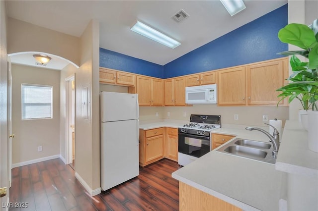 kitchen featuring sink, white appliances, dark hardwood / wood-style floors, vaulted ceiling, and light brown cabinets