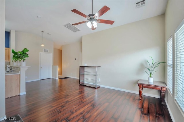 living room with lofted ceiling, dark wood-type flooring, sink, and ceiling fan