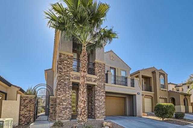 view of front facade featuring a garage, stone siding, driveway, a gate, and stucco siding