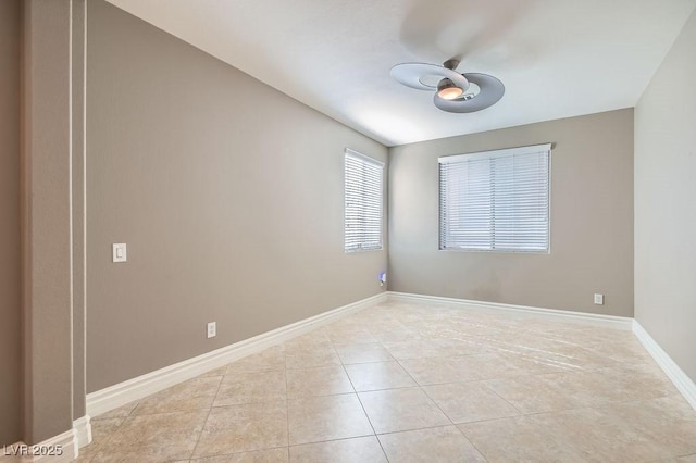 spare room featuring ceiling fan, baseboards, and light tile patterned floors