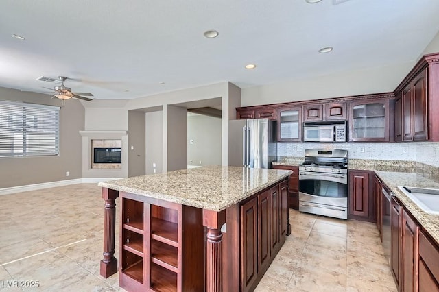 kitchen with stainless steel appliances, visible vents, open shelves, tasteful backsplash, and a glass covered fireplace