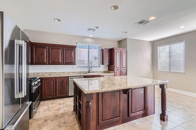 kitchen featuring appliances with stainless steel finishes, visible vents, a sink, and a kitchen island