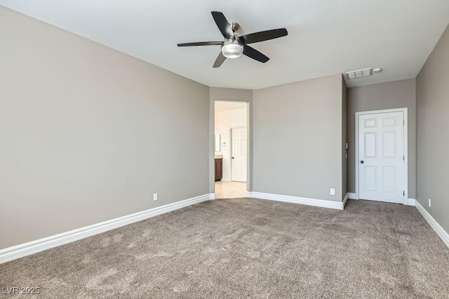 unfurnished bedroom featuring baseboards, visible vents, a ceiling fan, ensuite bath, and carpet floors