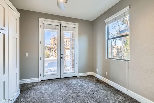 doorway featuring a healthy amount of sunlight, baseboards, and dark carpet