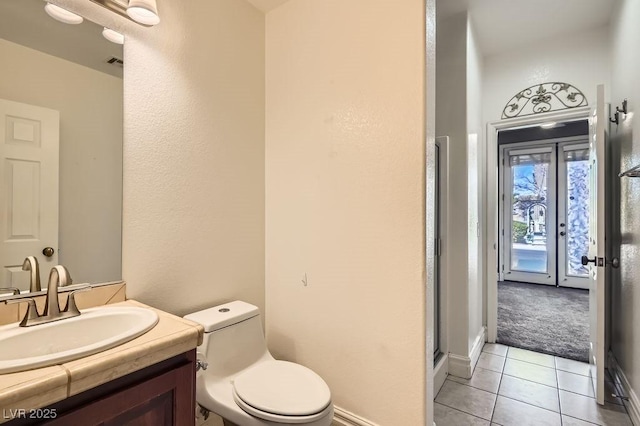 bathroom featuring visible vents, toilet, tile patterned floors, a shower with shower door, and vanity