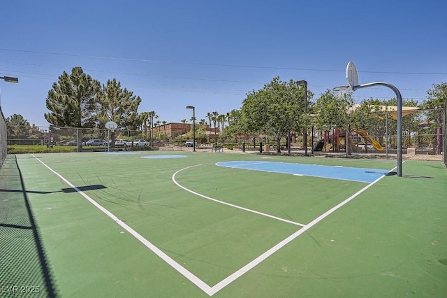 view of sport court featuring community basketball court, playground community, and fence