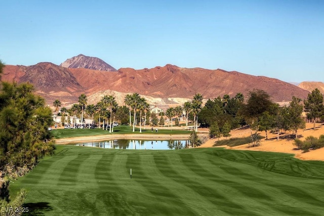 view of mountain feature with a water view and golf course view