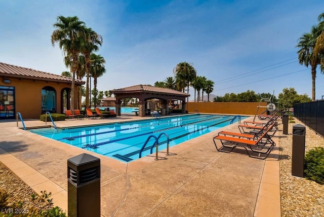 pool with a gazebo, fence, and a patio