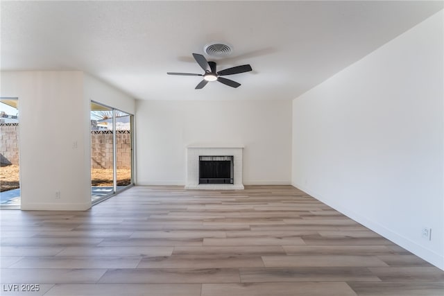 unfurnished living room with a fireplace, light hardwood / wood-style floors, and ceiling fan