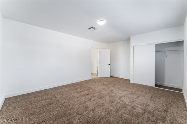 unfurnished bedroom featuring carpet and a closet