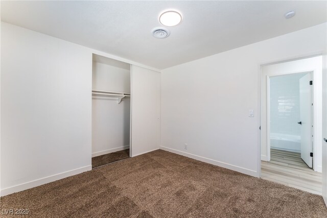 unfurnished bedroom with light carpet and a closet