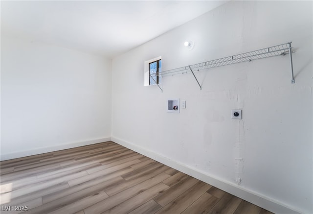 laundry room featuring electric dryer hookup, hookup for a washing machine, and light hardwood / wood-style flooring