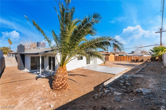 rear view of house with central AC and a patio