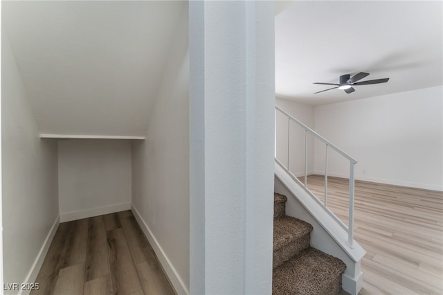 stairway with hardwood / wood-style floors and ceiling fan