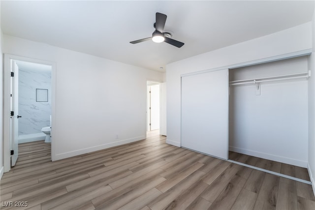 unfurnished bedroom featuring connected bathroom, hardwood / wood-style floors, a closet, and ceiling fan