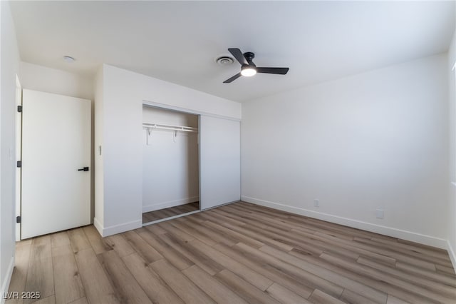 unfurnished bedroom with light hardwood / wood-style floors, a closet, and ceiling fan