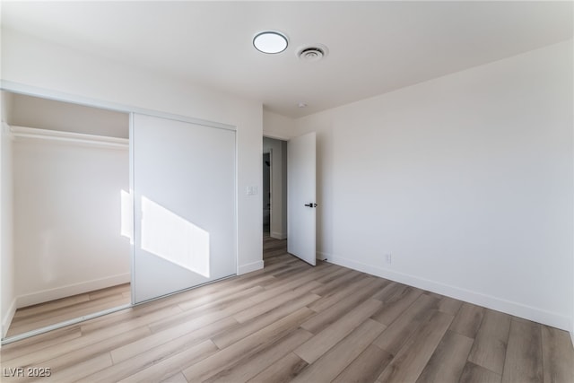 unfurnished bedroom featuring a closet and light wood-type flooring