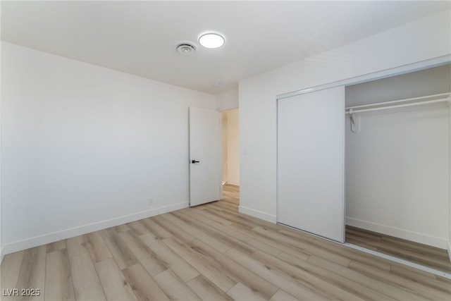 unfurnished bedroom featuring light hardwood / wood-style floors and a closet