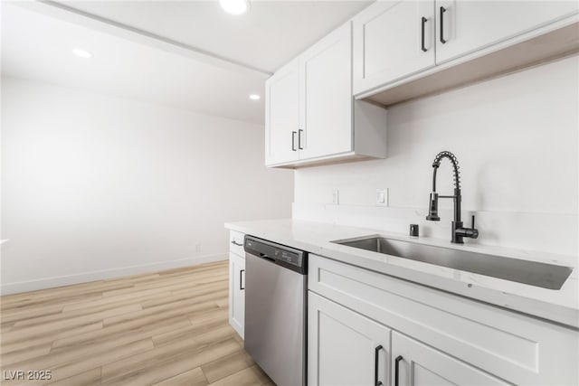 kitchen with sink, white cabinets, stainless steel dishwasher, light stone countertops, and light hardwood / wood-style flooring