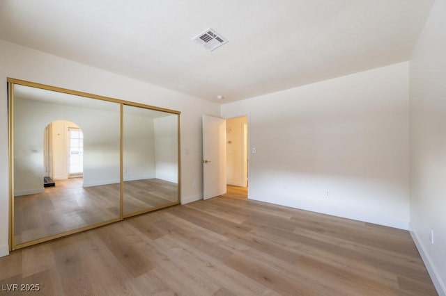 unfurnished bedroom featuring light hardwood / wood-style floors and a closet