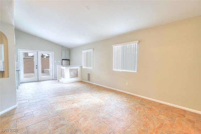 unfurnished living room with arched walkways, lofted ceiling, visible vents, baseboards, and french doors