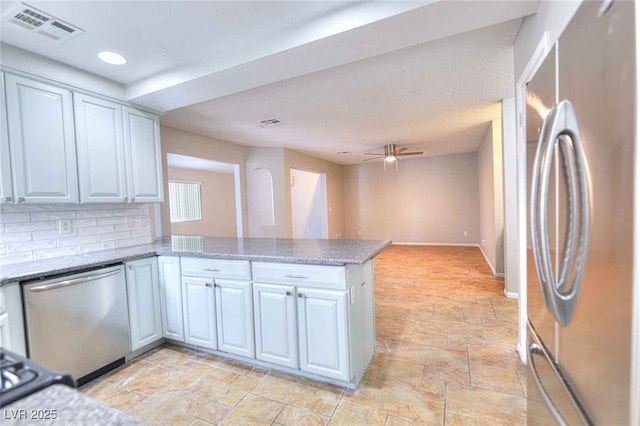 kitchen with tasteful backsplash, visible vents, ceiling fan, appliances with stainless steel finishes, and a peninsula