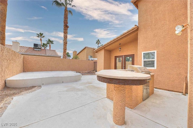 view of patio featuring french doors and a fenced backyard