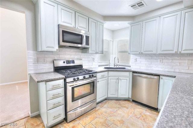 kitchen featuring stainless steel appliances, visible vents, a sink, and backsplash