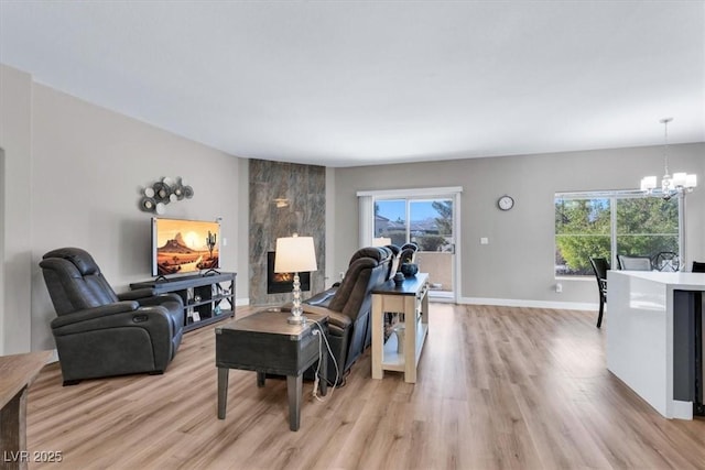 living room featuring light wood-type flooring and a notable chandelier